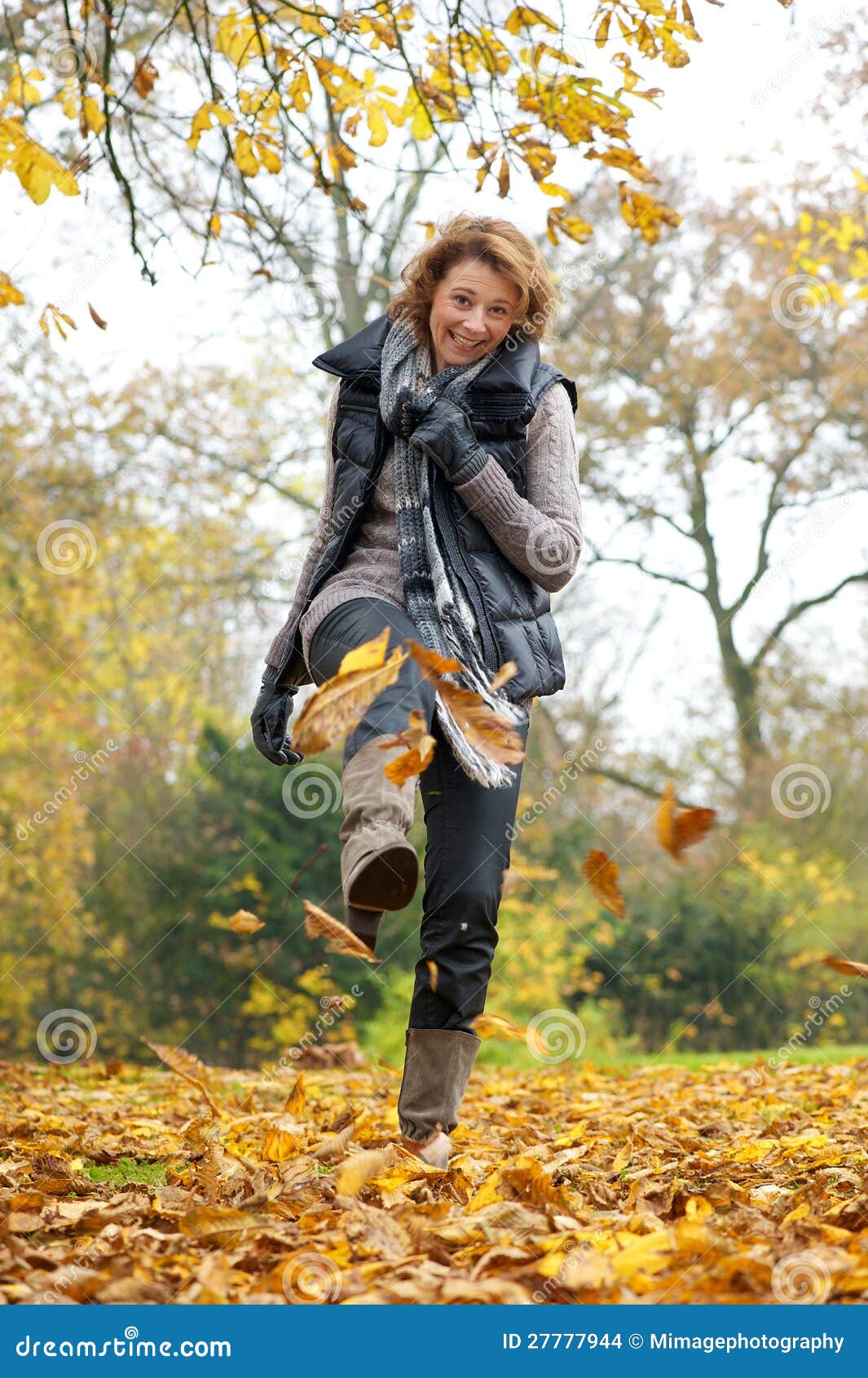 Woman Kicking Yellow Leaves In Autumn Stock Images - Image: 27777944