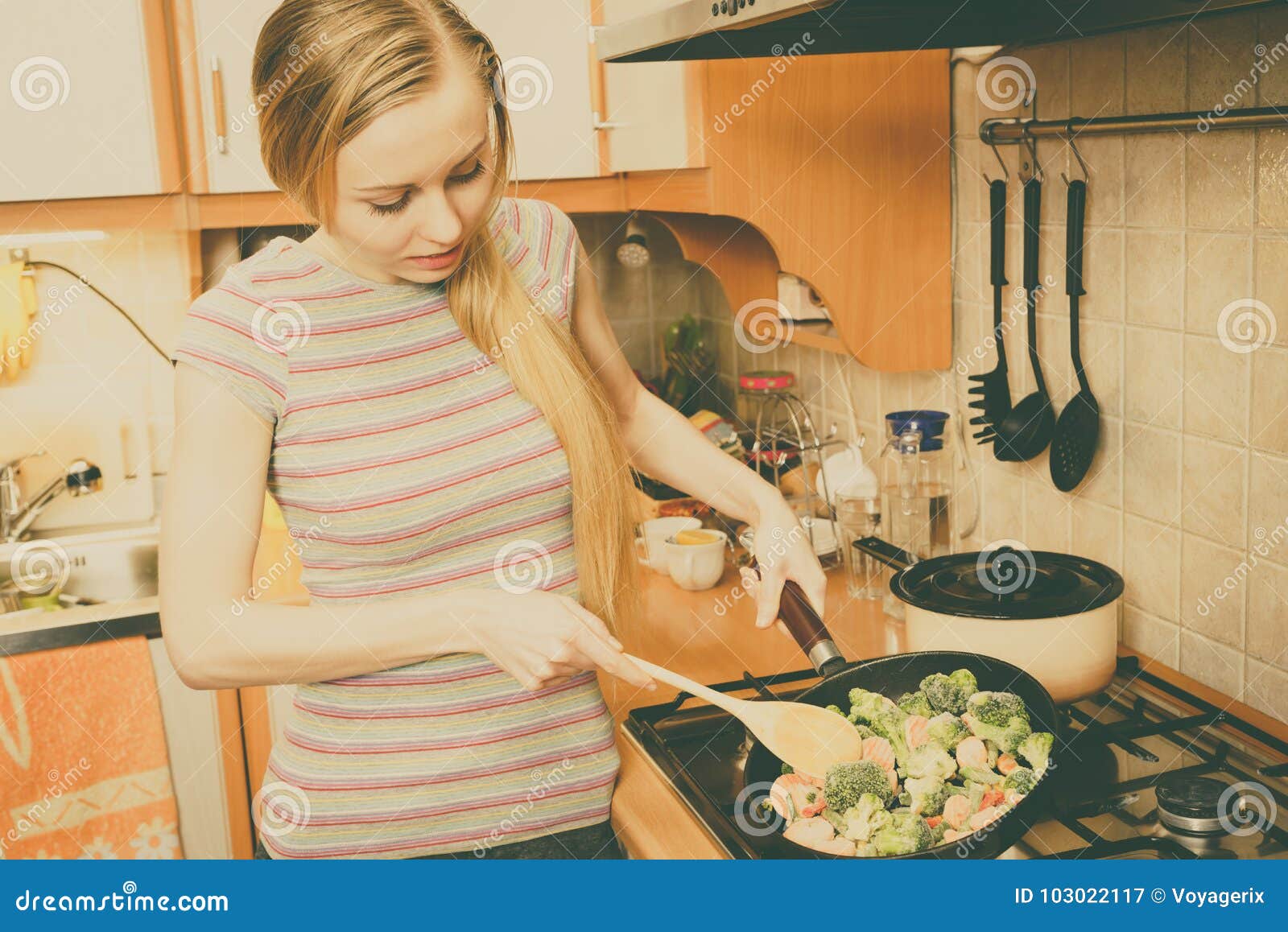 woman cooking stir fry frozen vegetable on pan