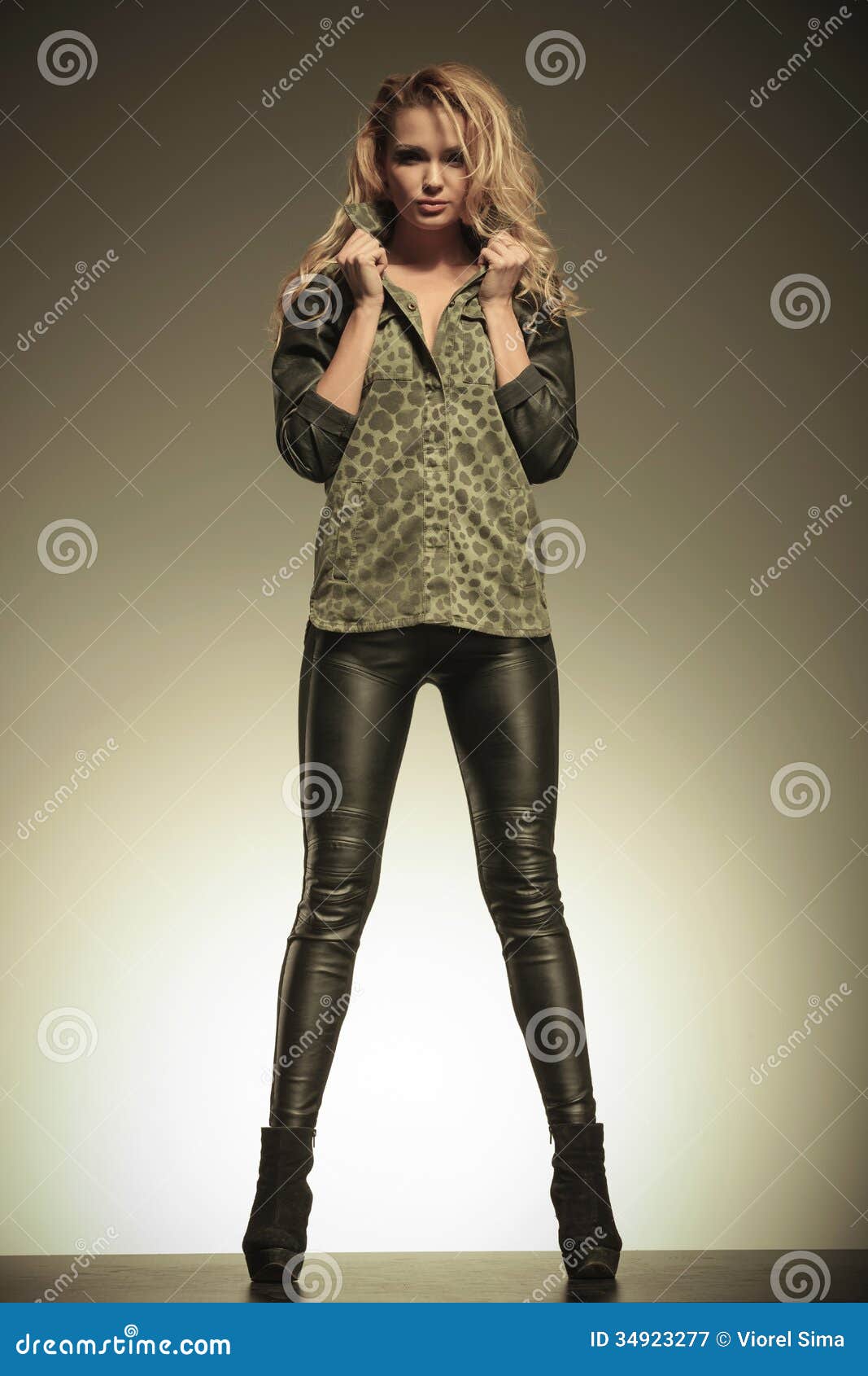 Woman In Leather Pants Posing By Holding Her Collar 