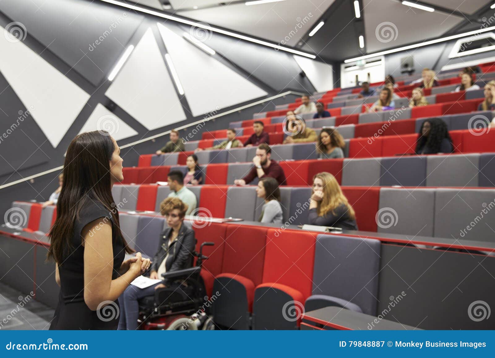 woman lecturing students in a university lecture theatre