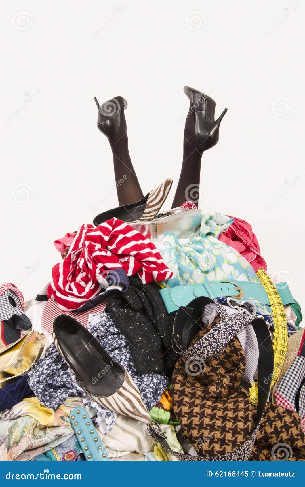 woman legs reaching out from a big pile of clothes and accessories.