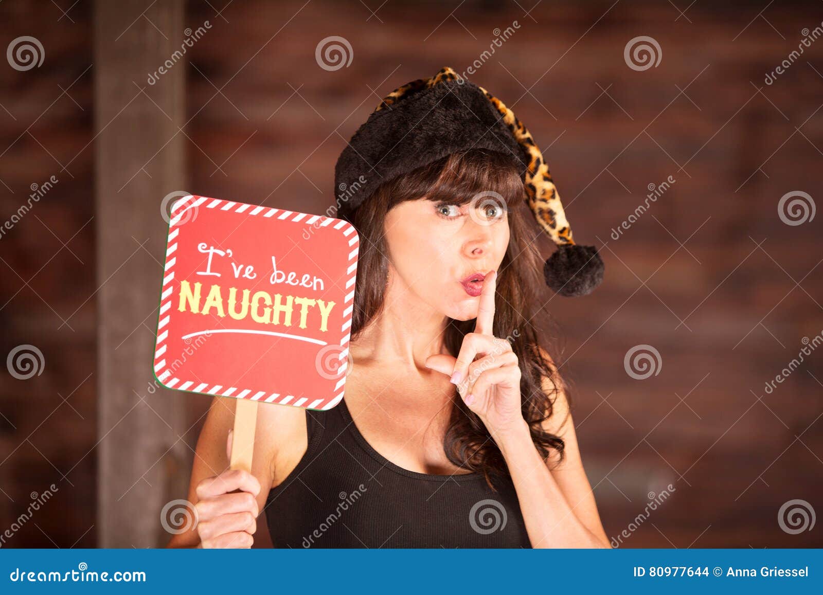 Woman in Leopard Skin Hat with Naughty Sign Stock Photo
