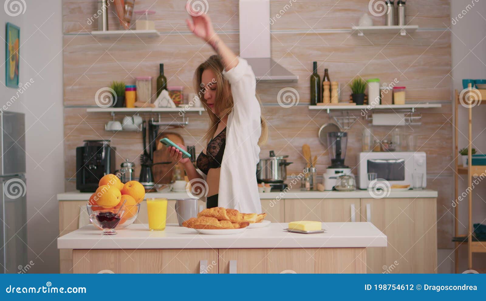 sexy and beautiful girl in lingerie in the kitchen preparing breakfast  Stock Photo