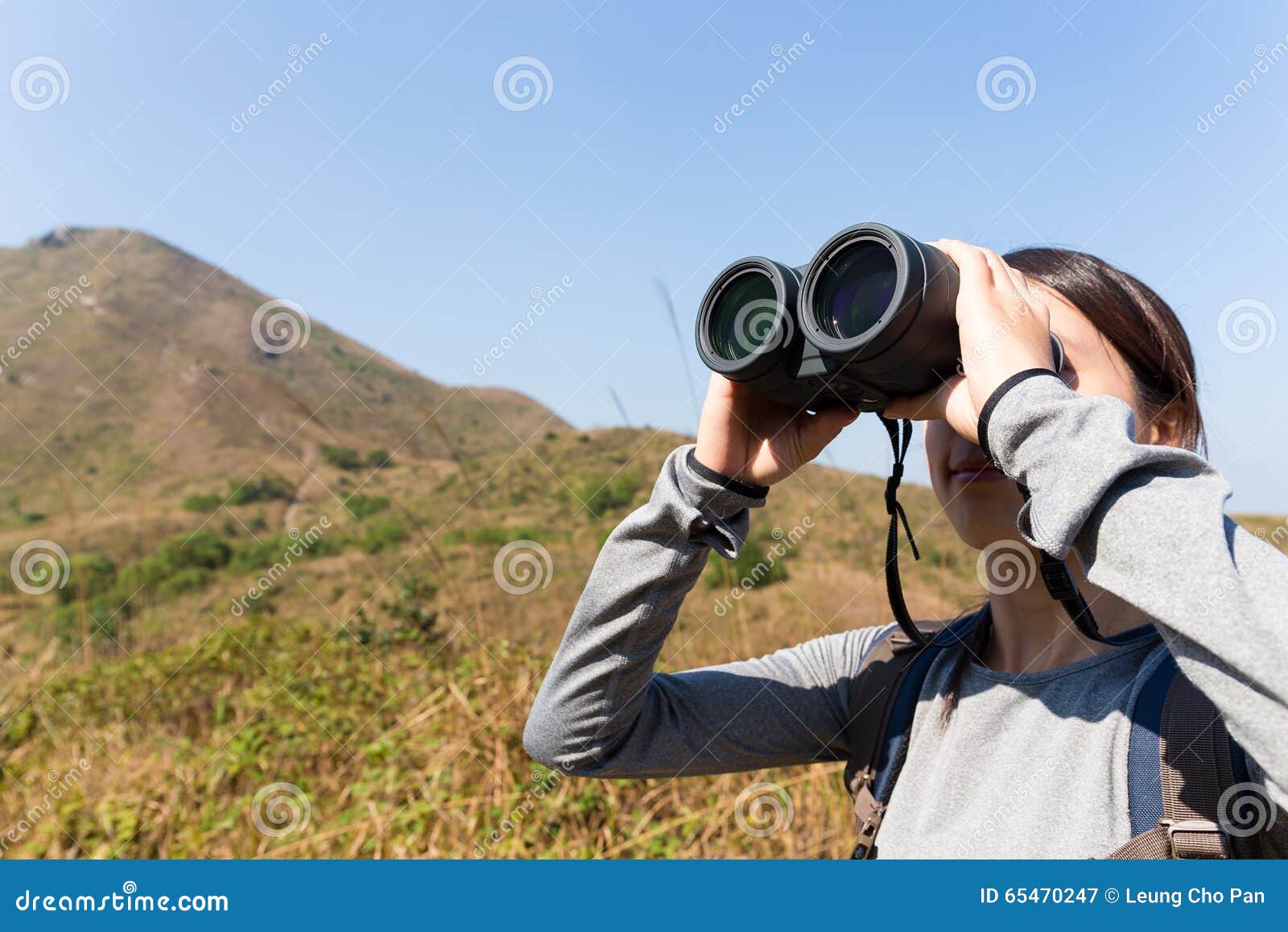 woman look though binocular when going hiking