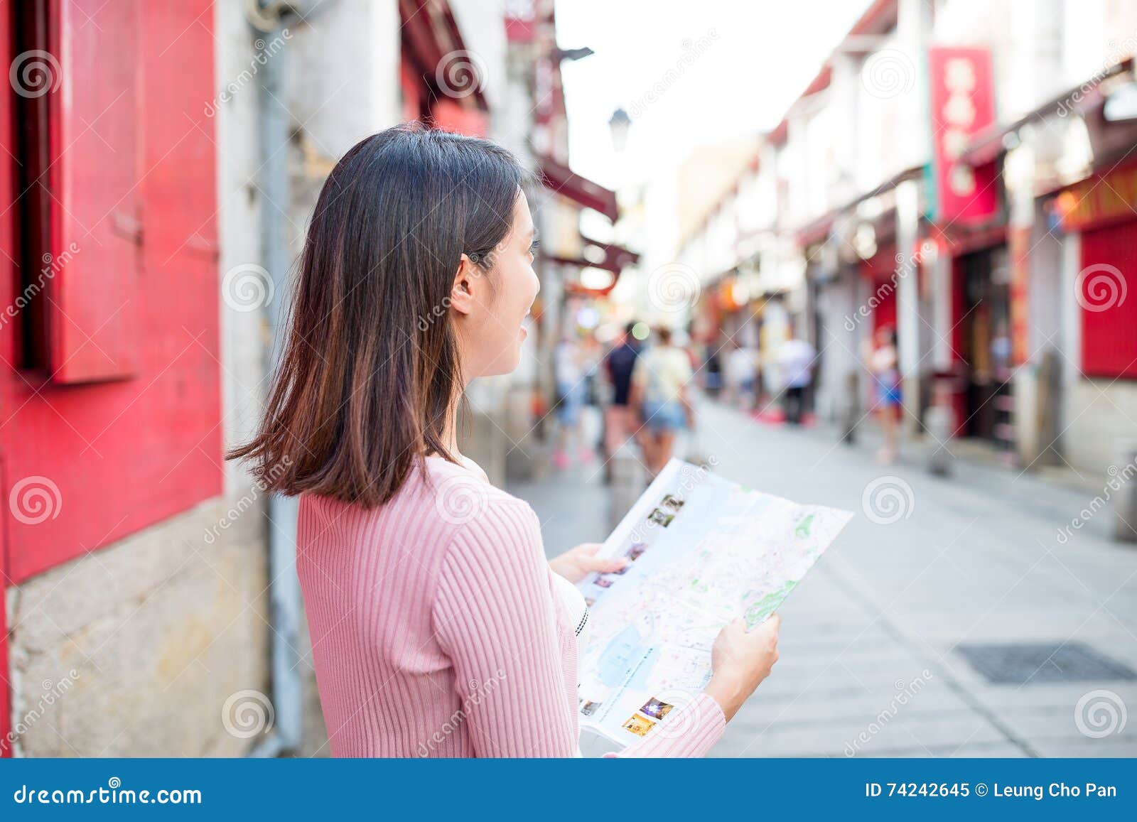 woman looking at city map in rua da felicidade of macao city