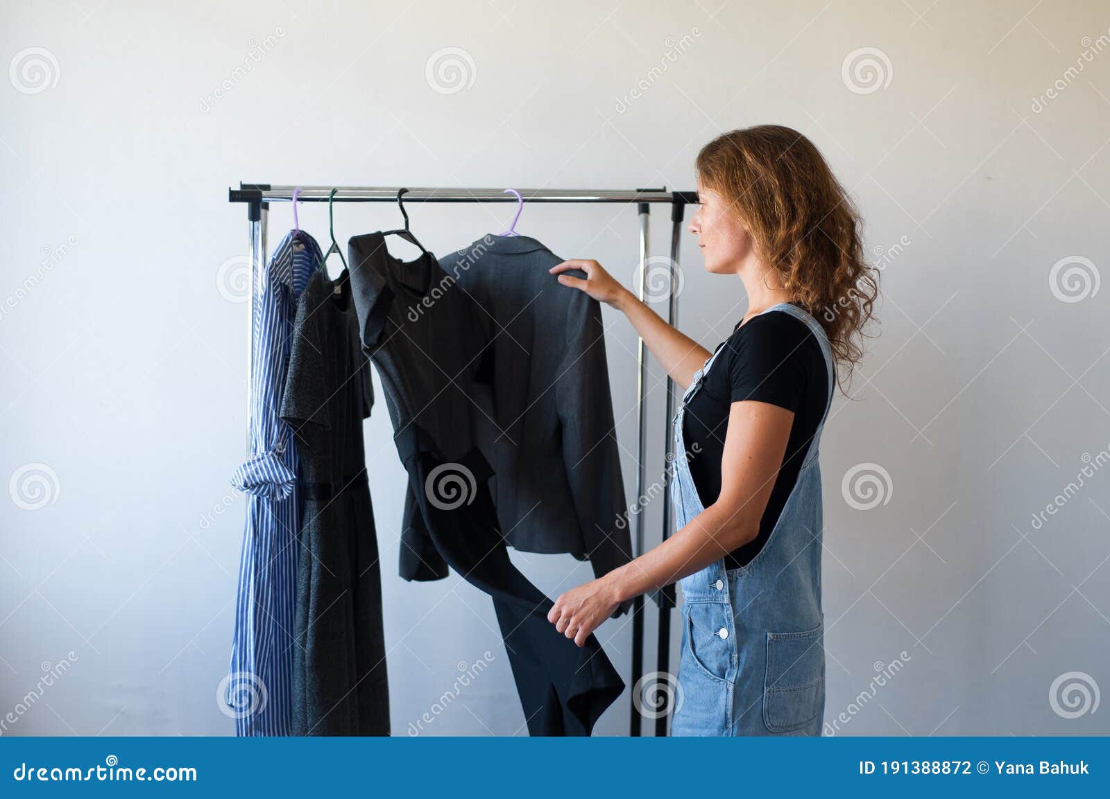 woman looking at clothes. young shopping fun. clothes on a rack