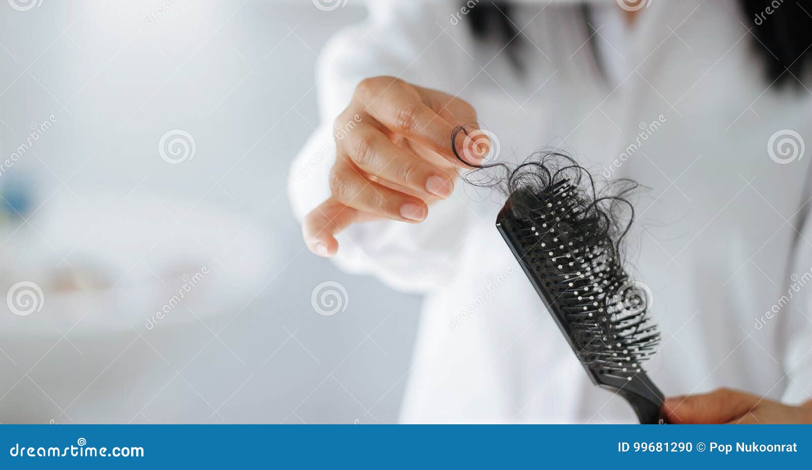 woman losing hair on hairbrush in hand, soft focus