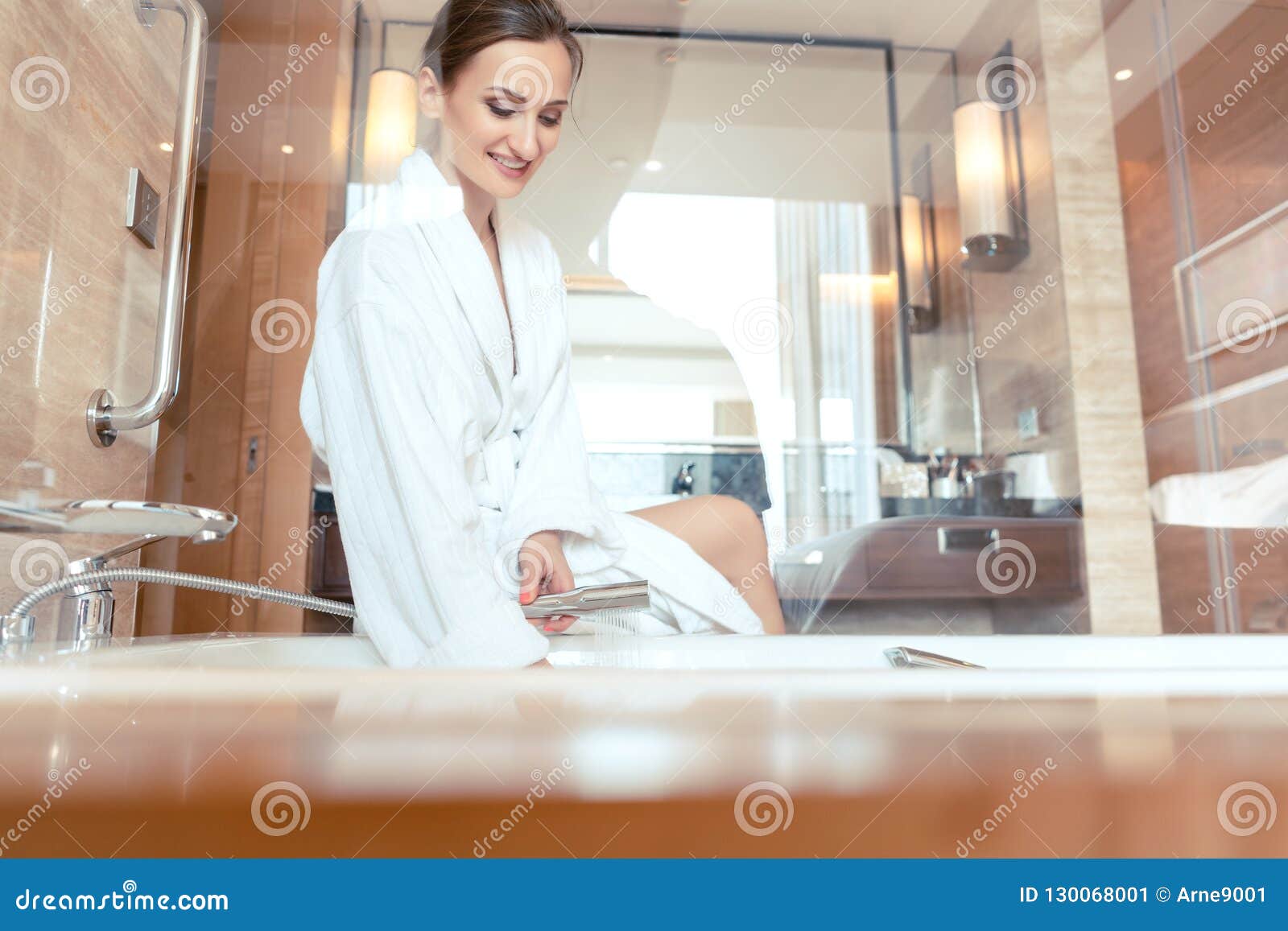 Woman In Luxurious Hotel Bathroom Letting Water In The Bathtub Stock