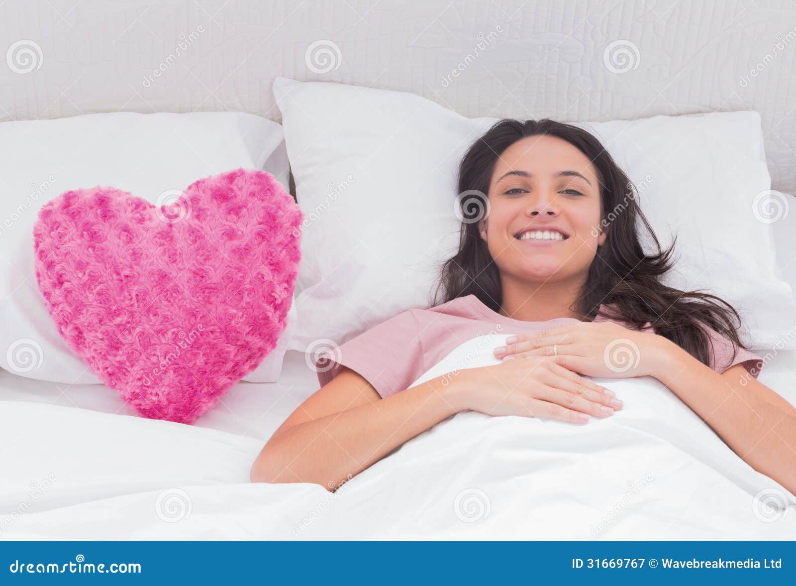 На кровати одна подушка сердце. Розовая подушка сердце. Девушка на розовой подушке. Подушка сердечком лежит. Обнимает подушку сердечко.