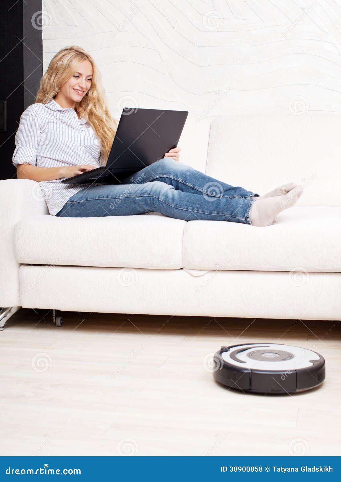 Woman Lying On The Sofa And The Robot Vacuum Cleaner Cleans Stock