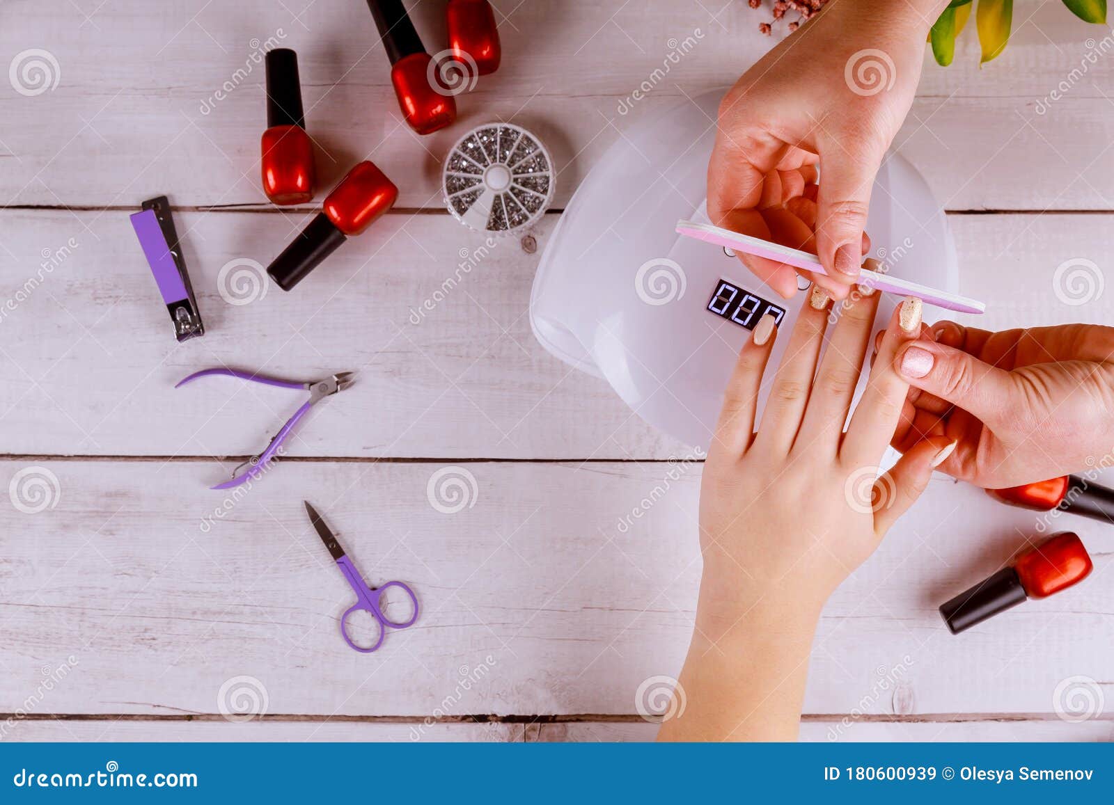 woman making manicure with nail board or nailfile