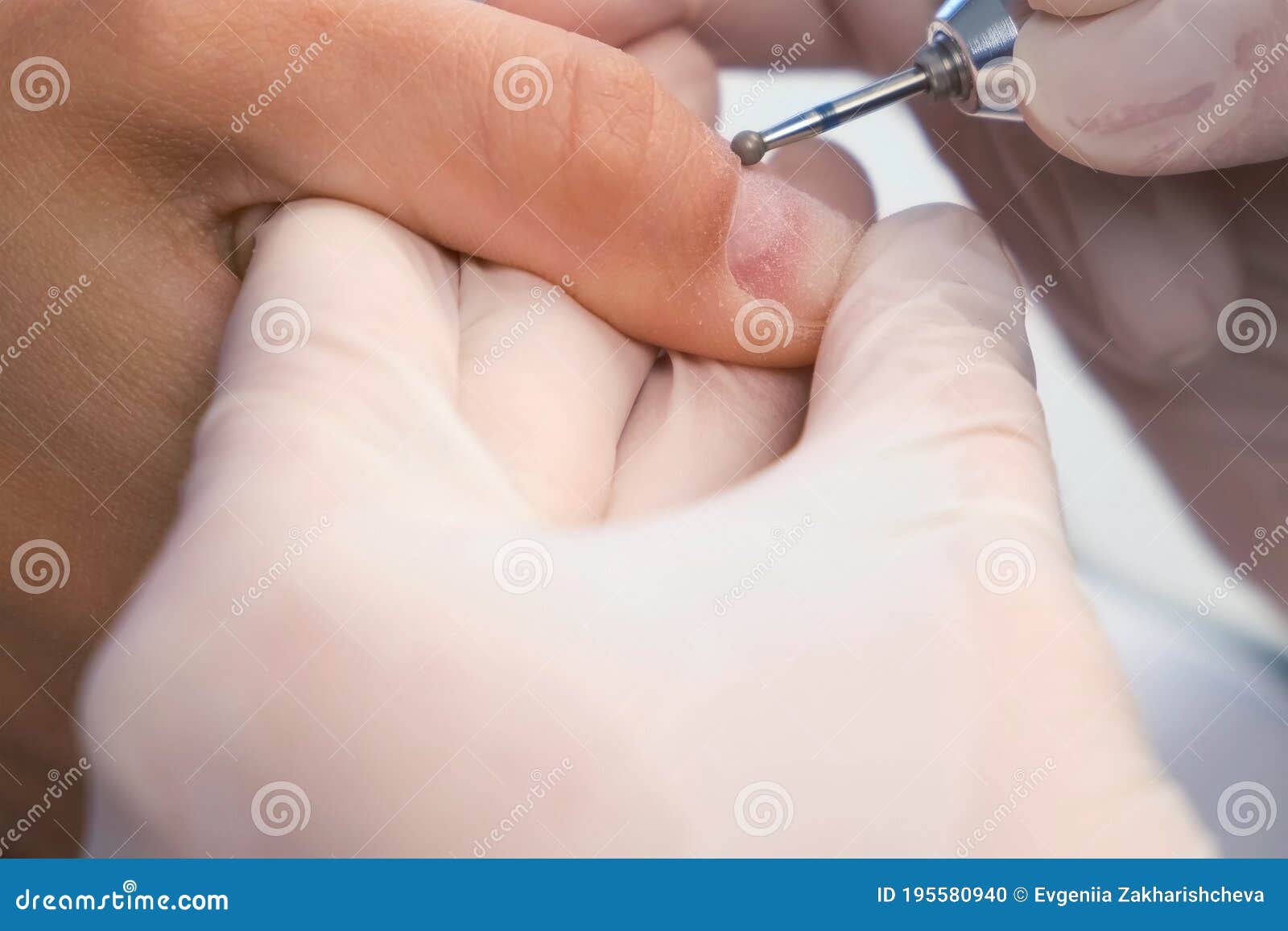 woman manicurist removing cuticle and pterygium using apparatus, closeup view.