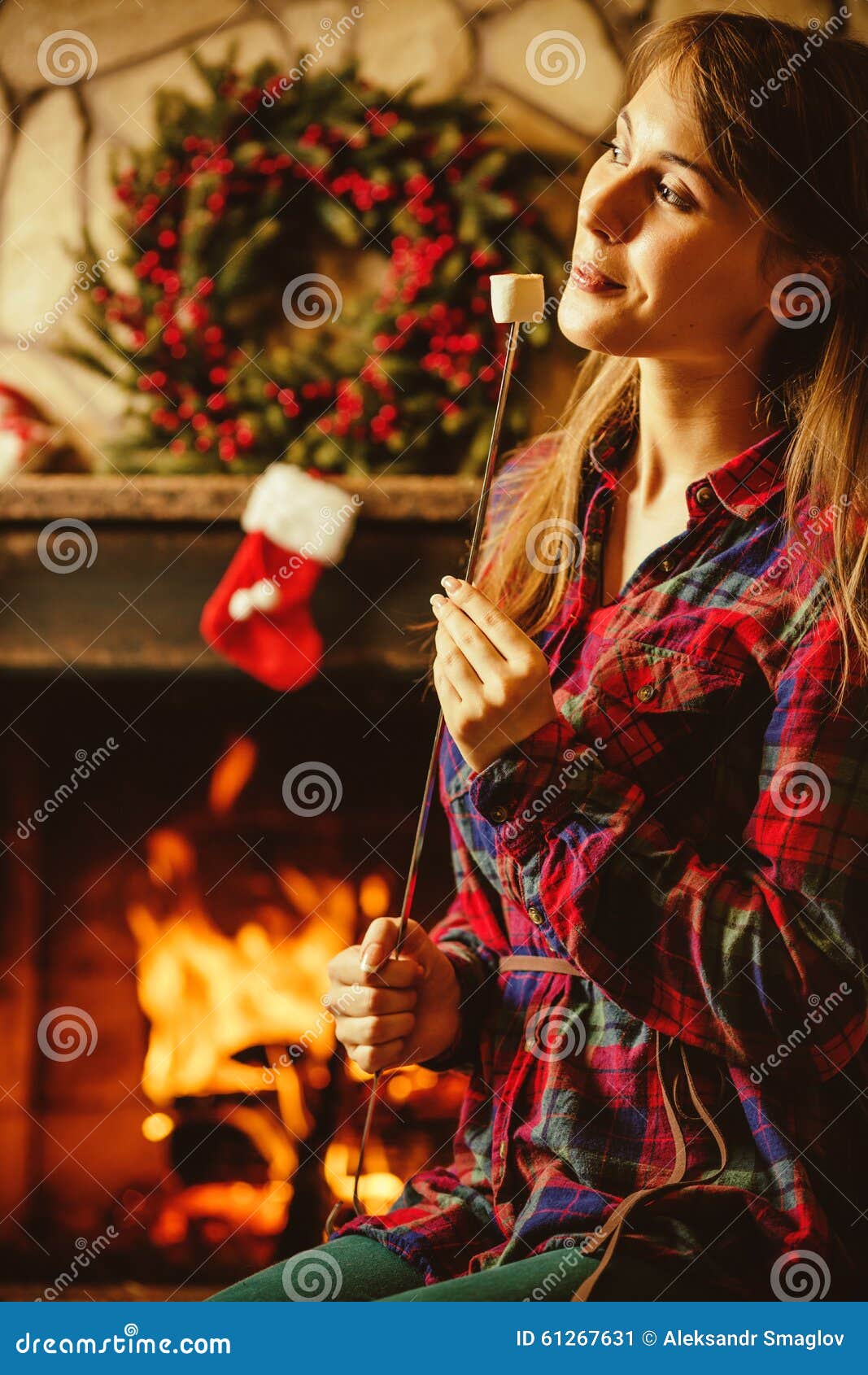 Woman with Marshmallow by the Fireplace. Young Woman Smiling and Stock ...