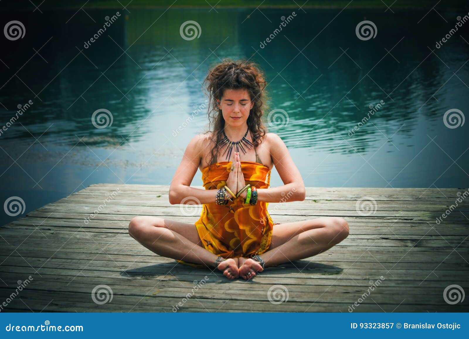 woman in a meditative yoga position by the lake