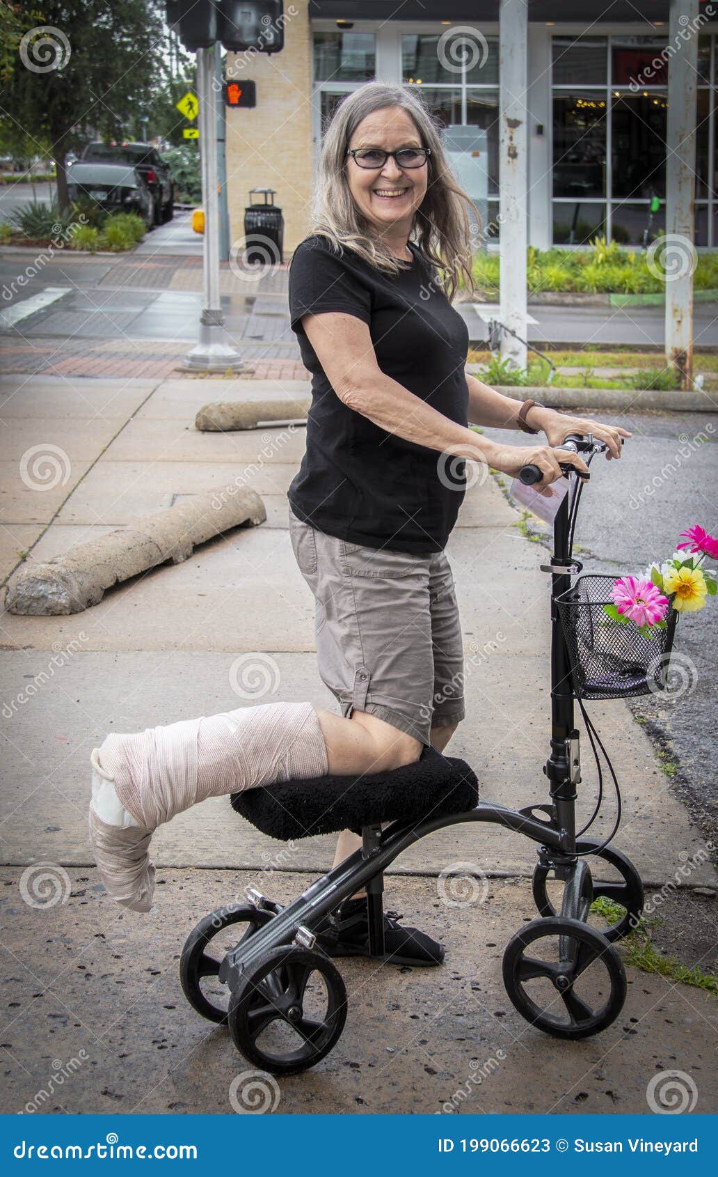 woman on mobility scooter on street with leg wrapped smiling at camera