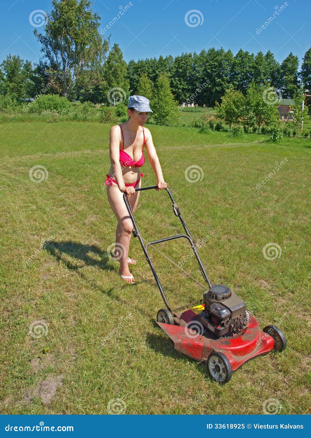 Woman mowing grass stock image. 