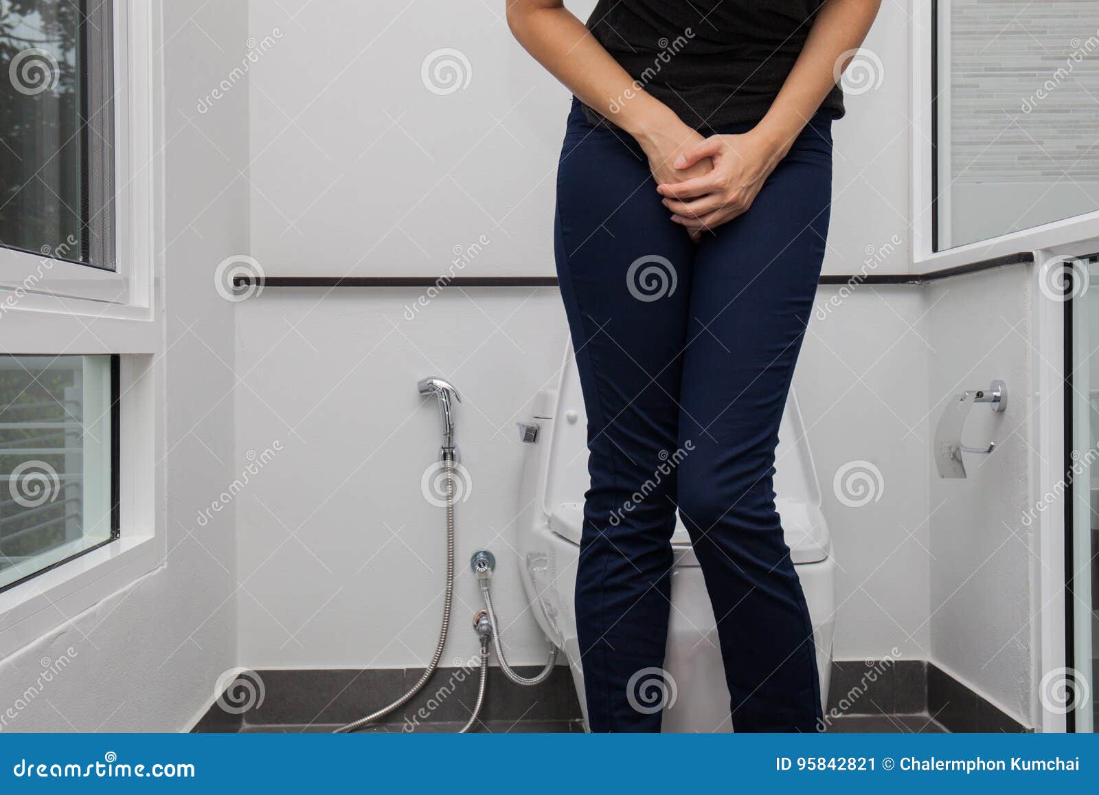 A girl wearing black sandals pissing in the common WC