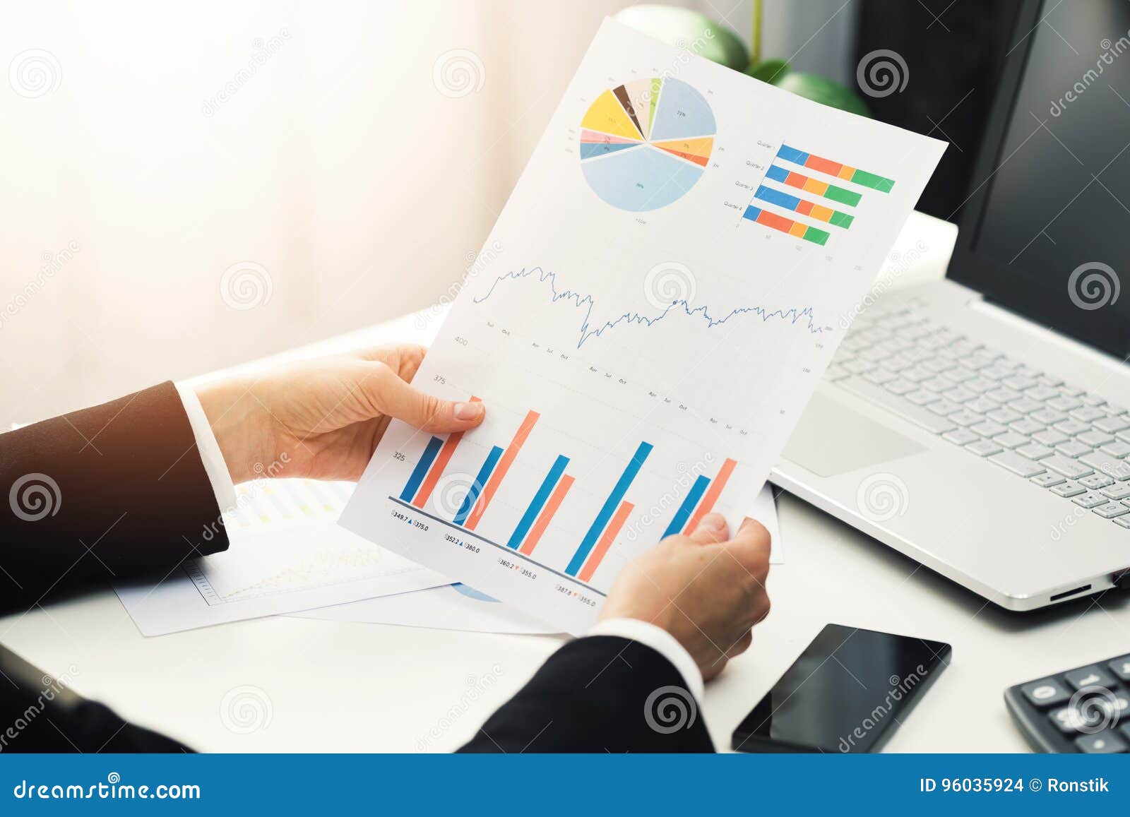 woman at office analyzing business financial graph reports