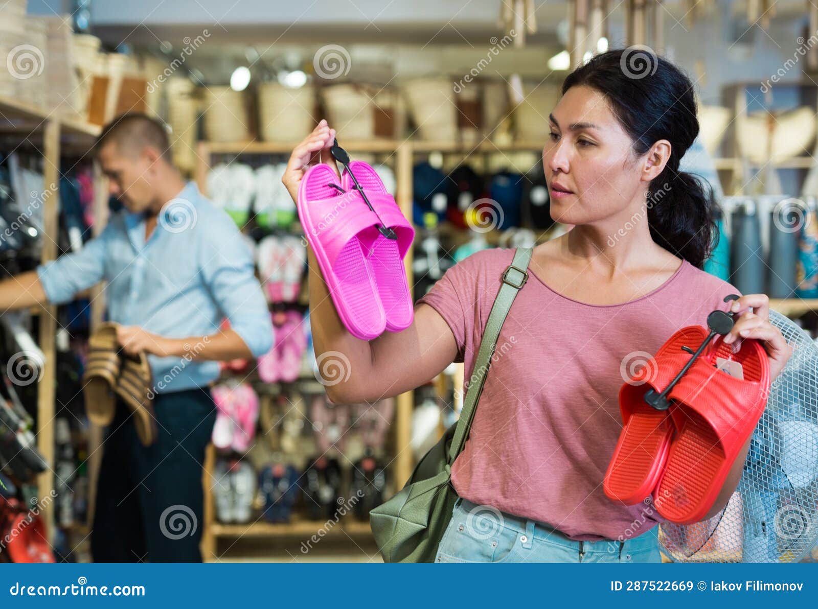woman with pairs of jandals in store