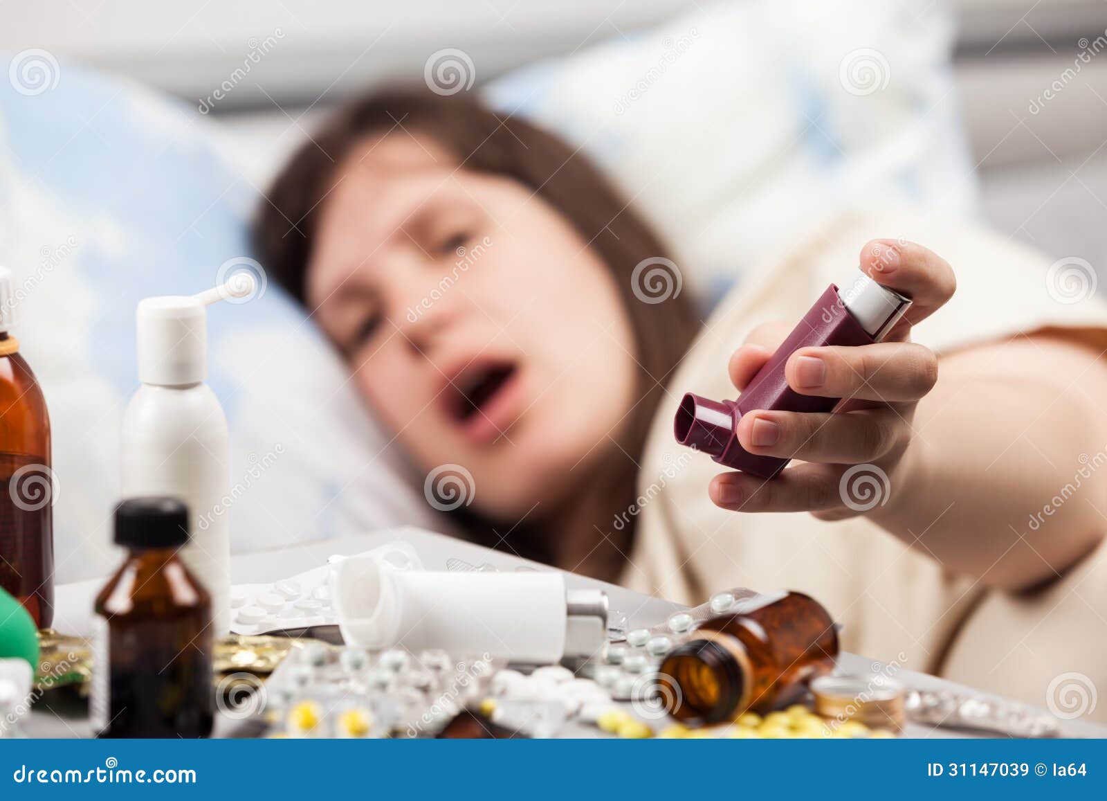 woman patient in bed hand holding asthmatic inhaler