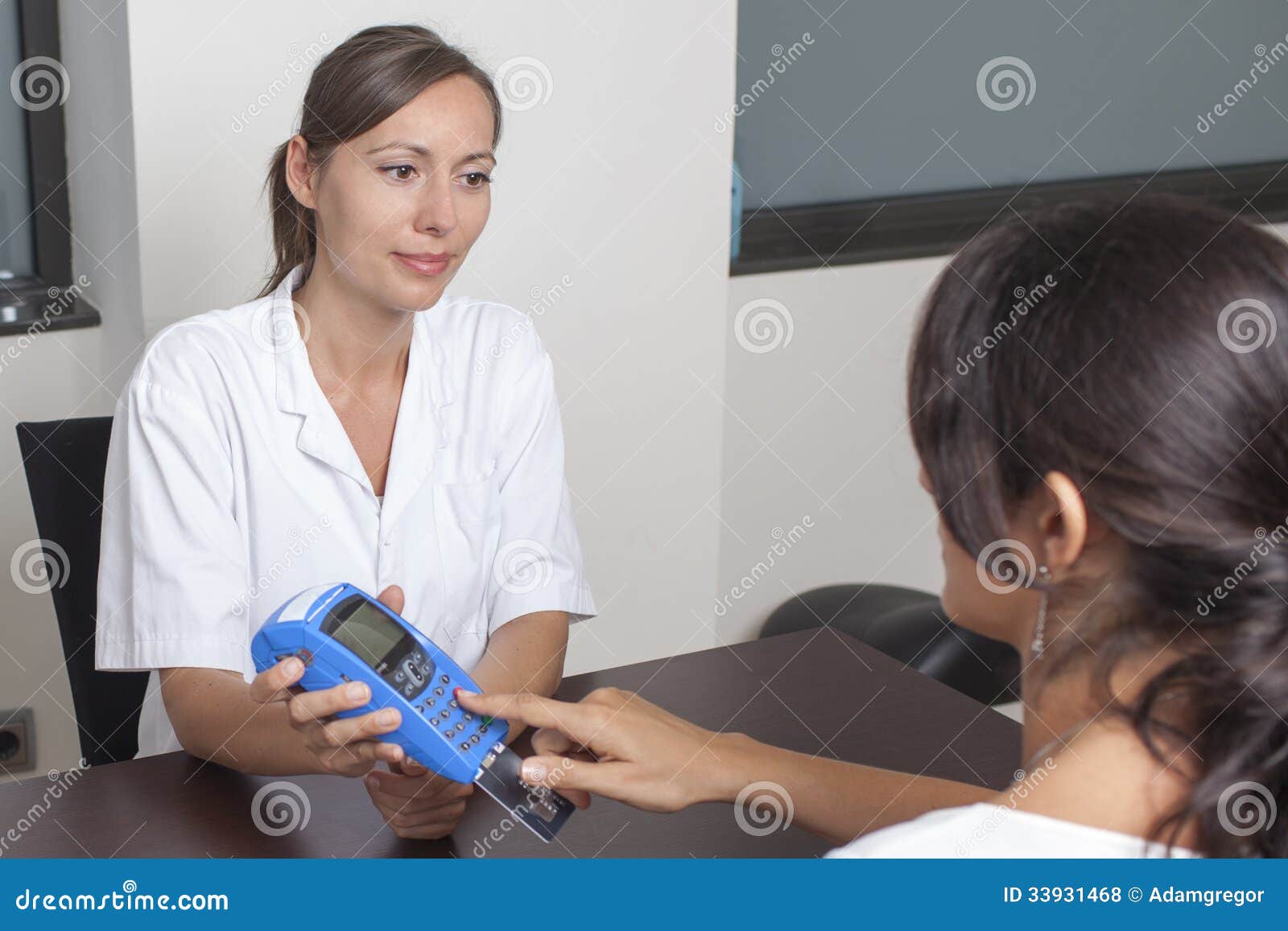 woman paying the doctor with creditcard