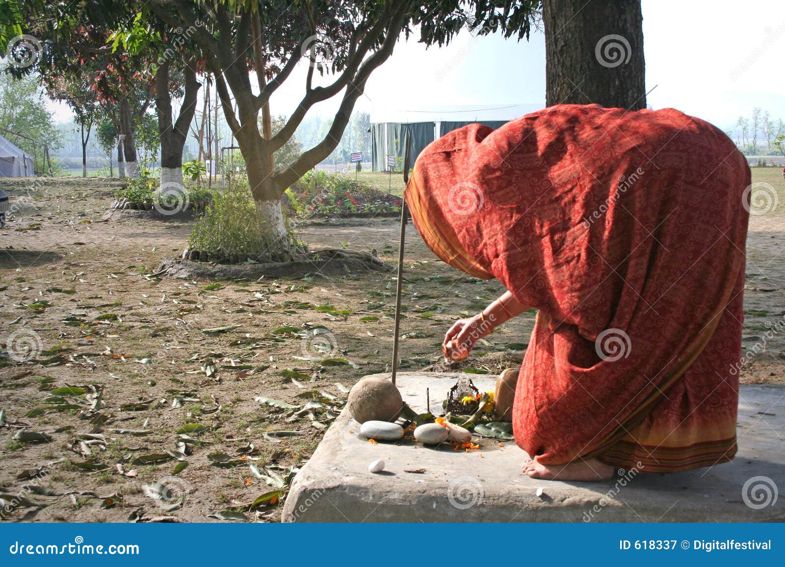 woman performs traditional morning worship ritual in courtyard