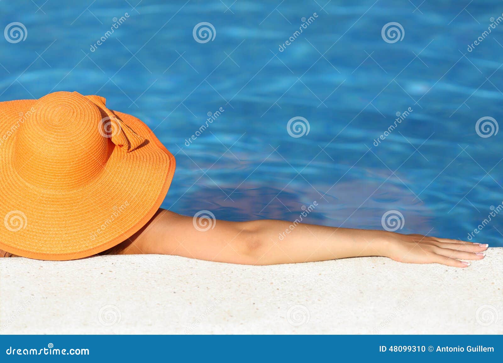 woman with picture hat bathing relaxed in a pool enjoying vacations
