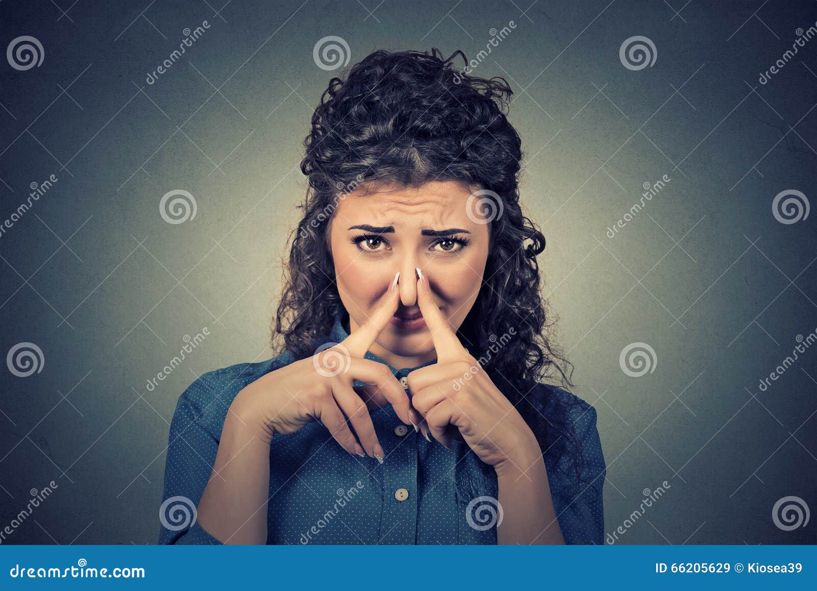 woman pinches nose with fingers looks with disgust something stinks bad smell