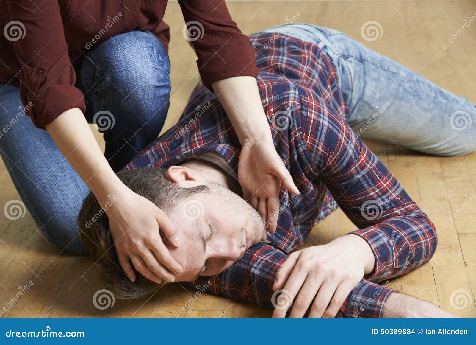 woman placing man in recovery position after accident