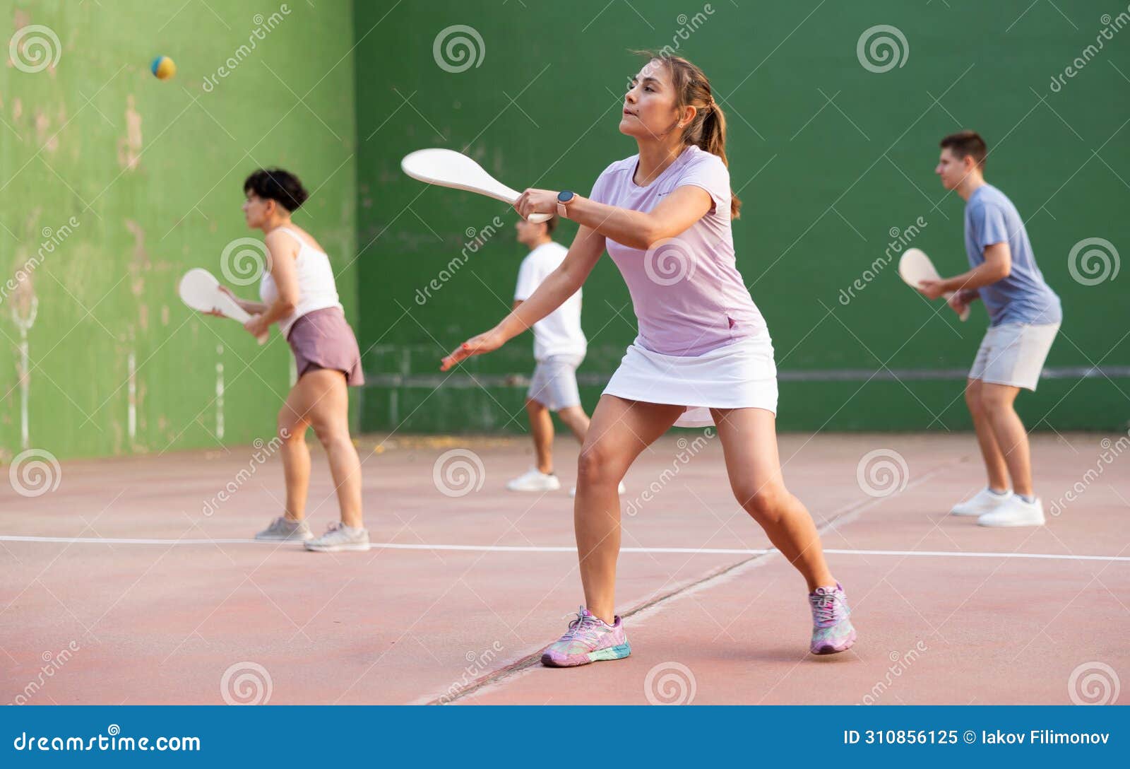 woman playing basque pelota on outdoor pelota court