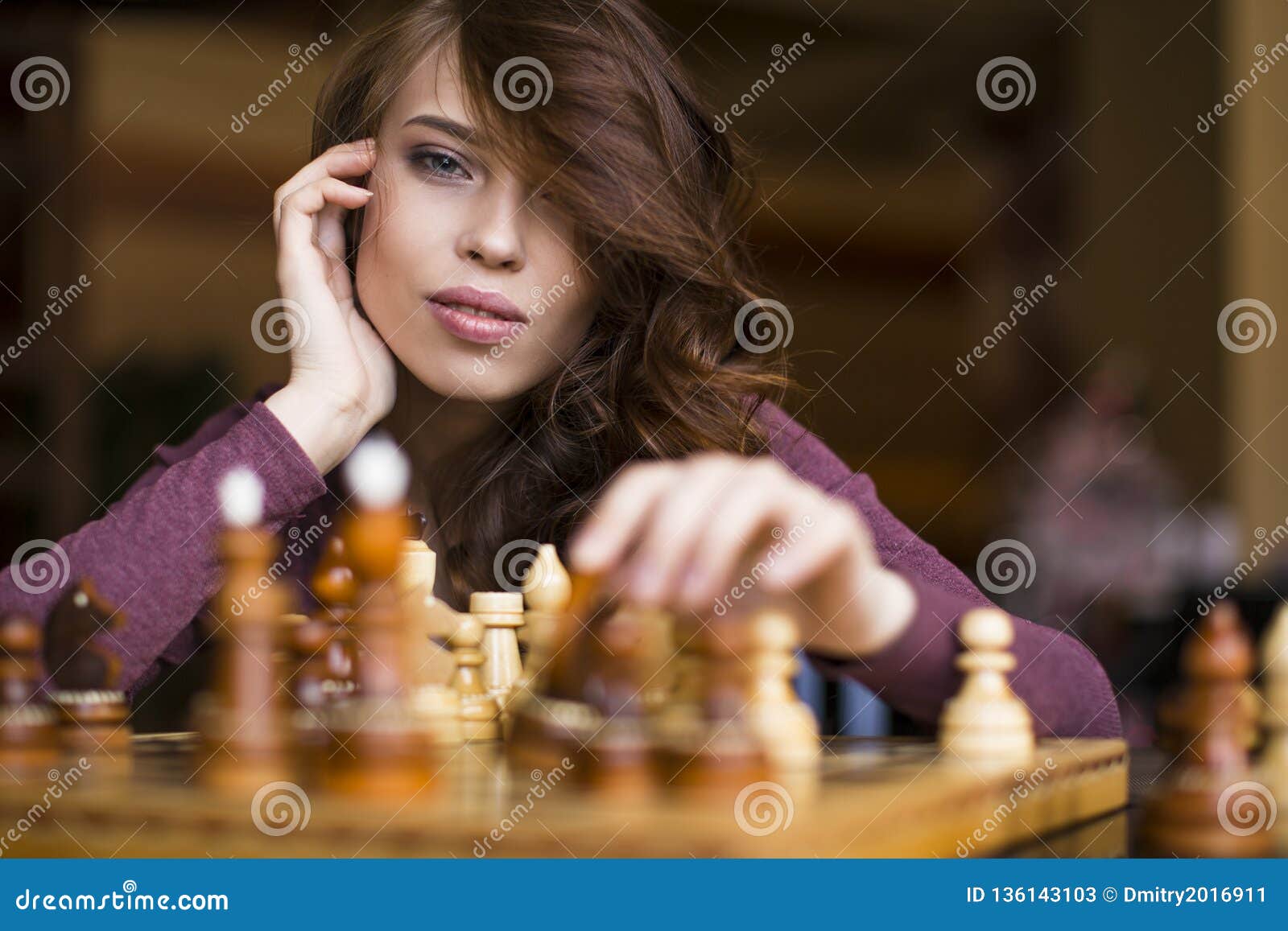 Woman playing chess thinking of next move Stock Photo - Alamy