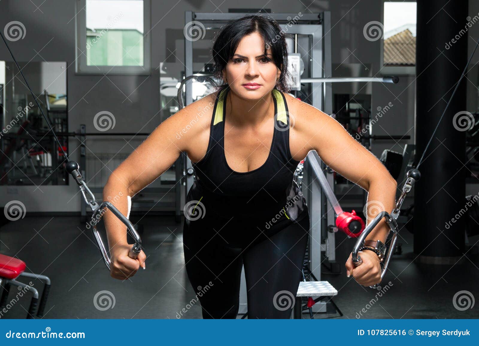Woman Plus Size in Gym Doing Exercises with Training Apparatus