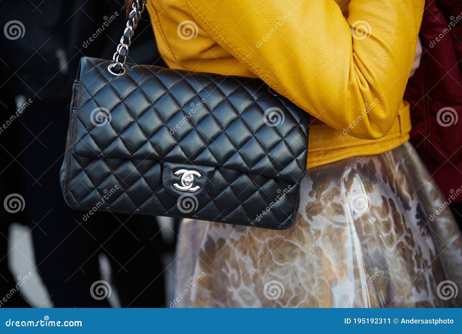 Woman with black leather Chanel bag and silver leather jacket