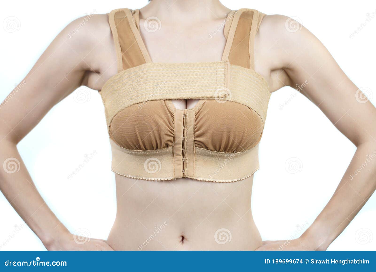 Woman posing in support bra after breast augmentation plastic surgery with  silicone breast implants. Stock Photo