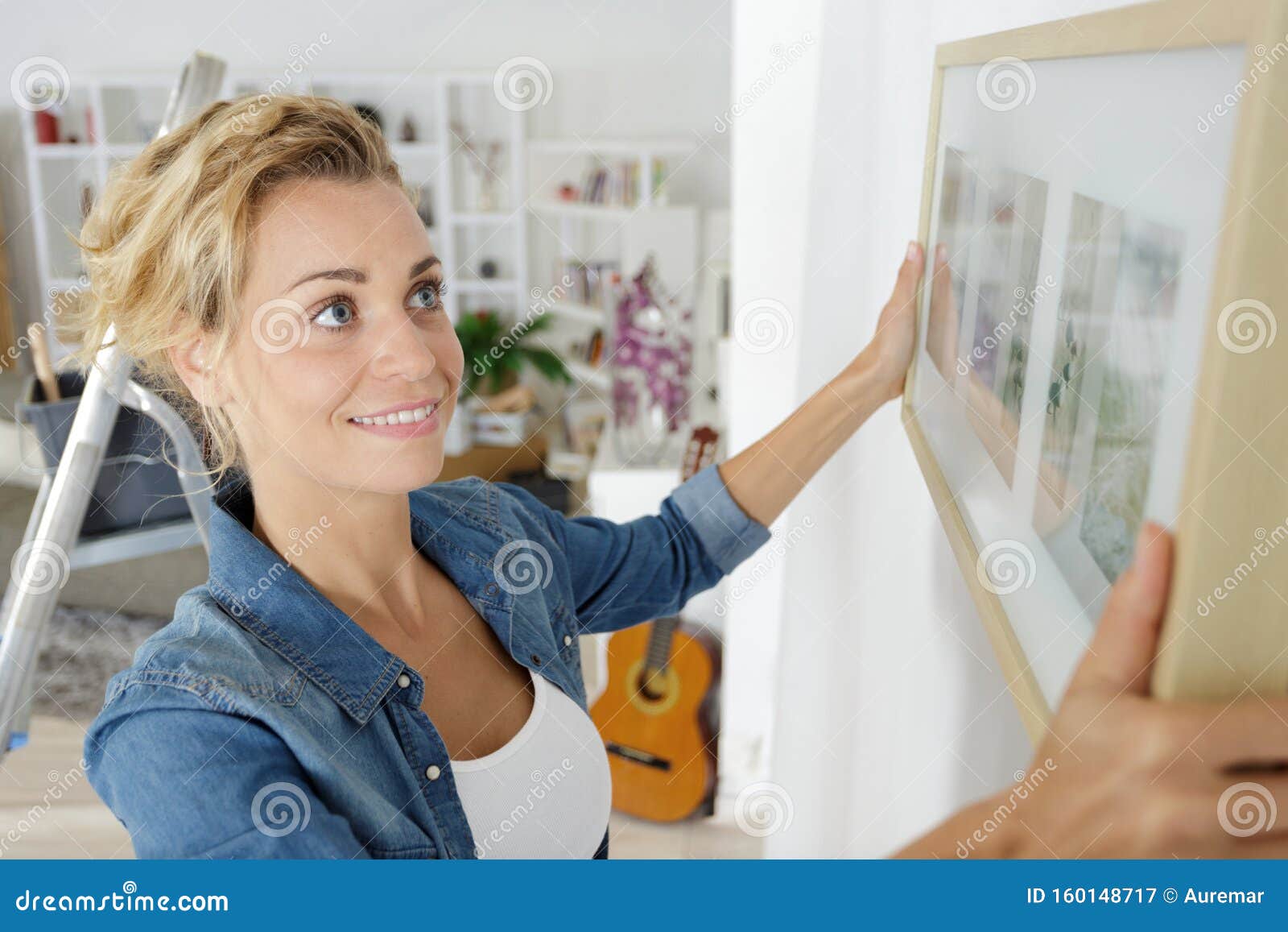 Woman Positioning Picture Frame on Wall Stock Image Image of casual