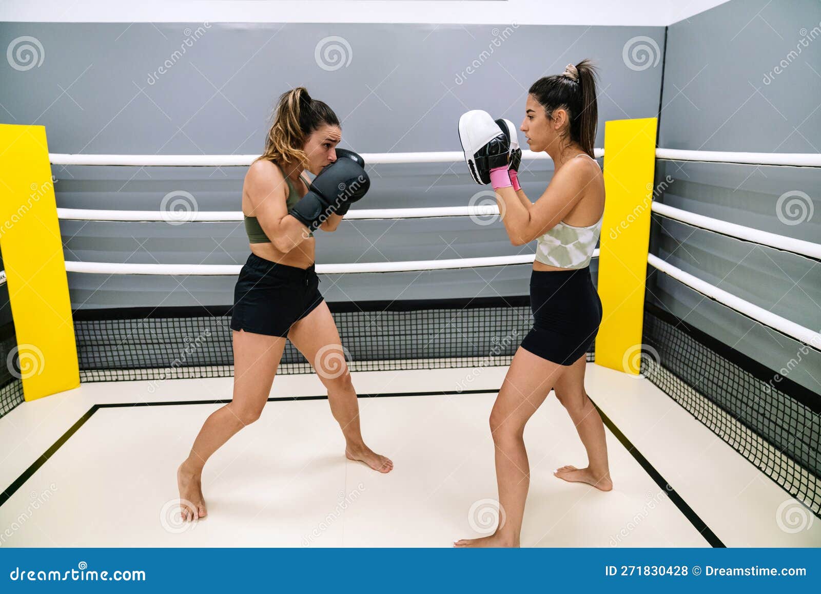 A Woman Practicing Some Punches with Her Instructor in the Boxing Ring
