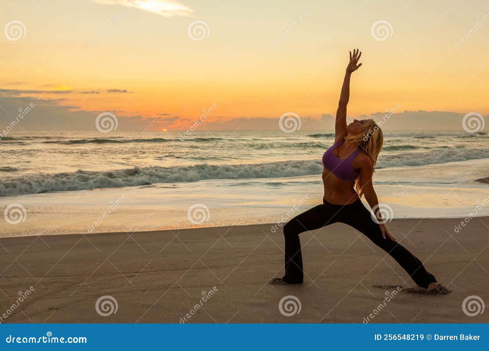 Young woman practicing yoga at beach