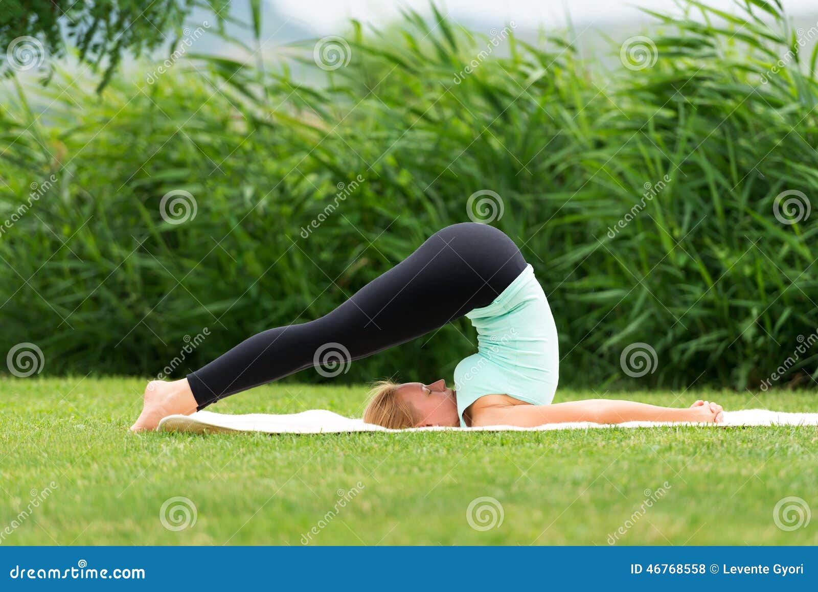 woman practicing yoga halasana plow pose