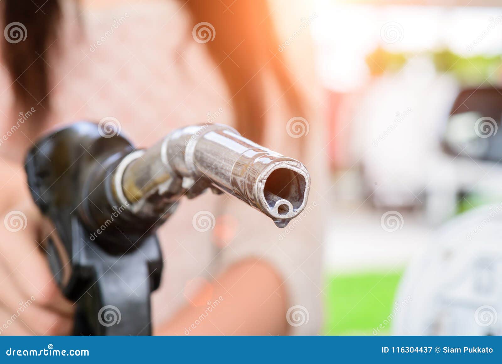 woman pumping gasoline fuel in car at gas station.