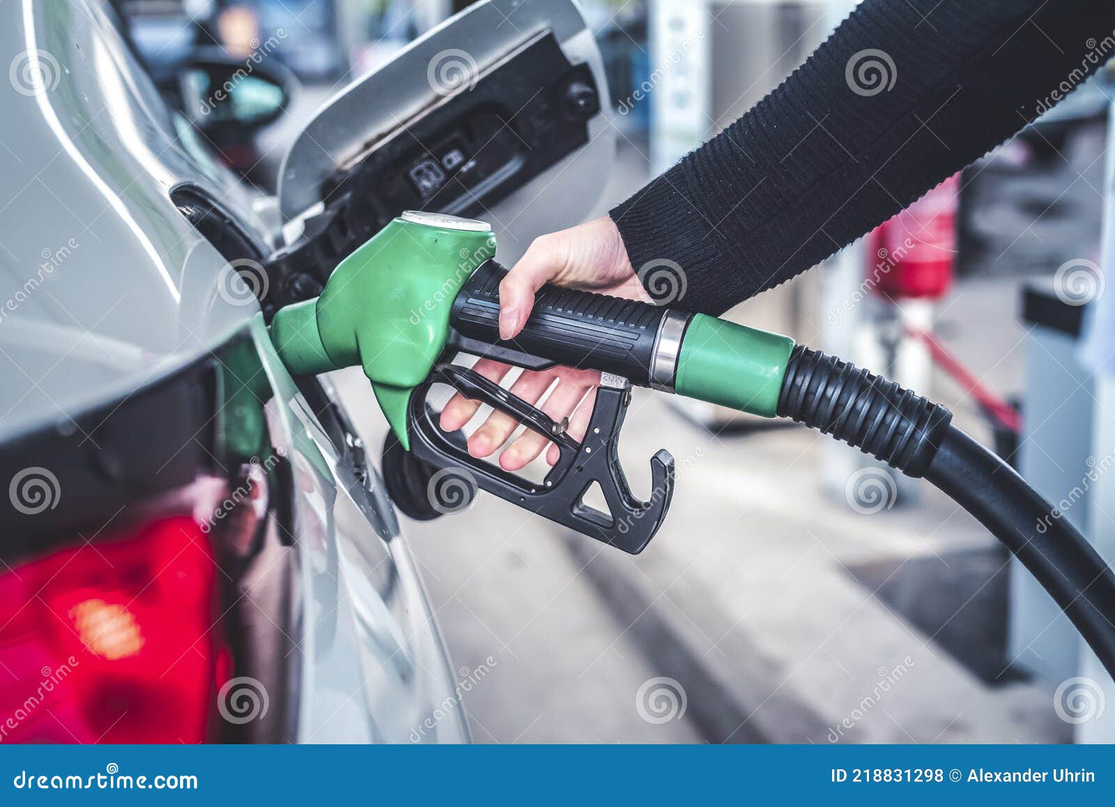 woman pumping gasoline fuel in car at gas station.