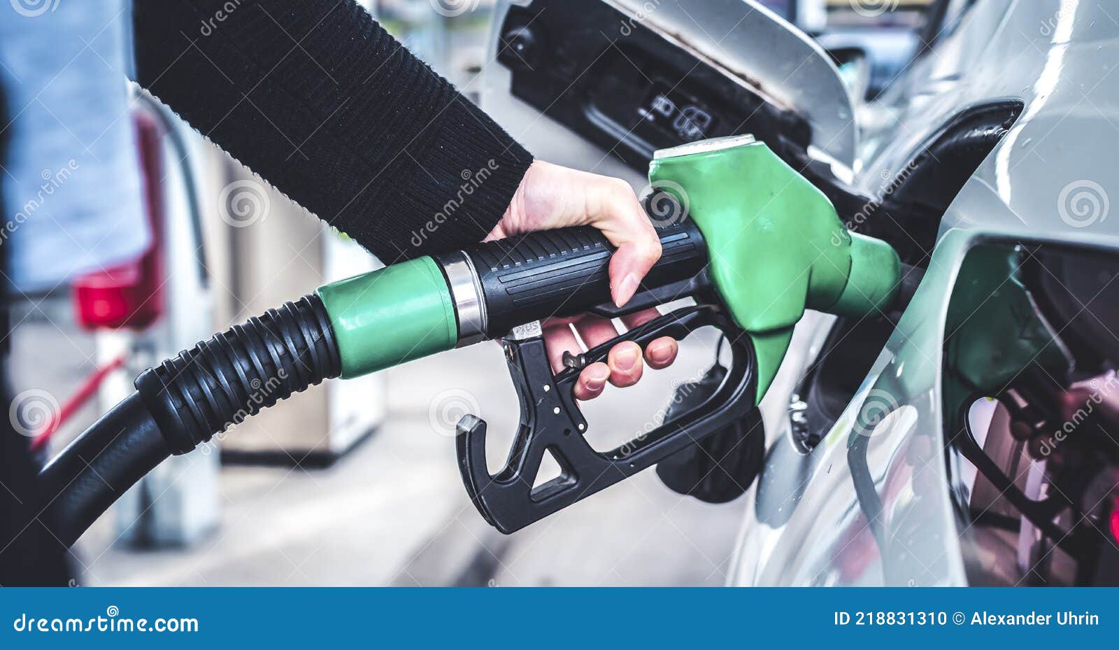 woman pumping gasoline fuel in car at gas station.