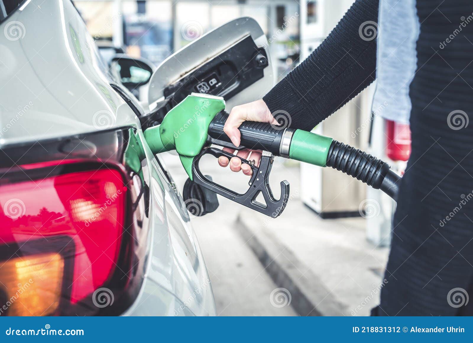 woman pumping gasoline fuel in car at gas station.