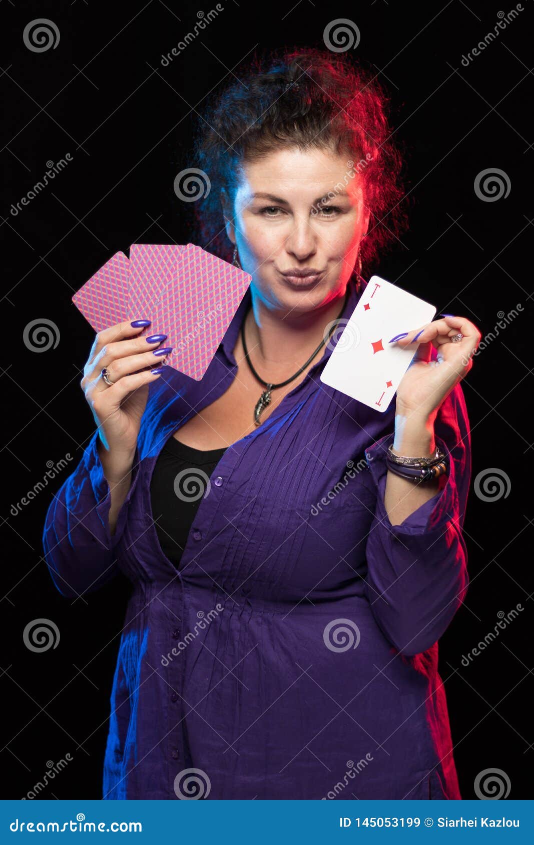 A Woman in Purple Clothes Holds a Deck of Cards and Shows Tricks Stock ...