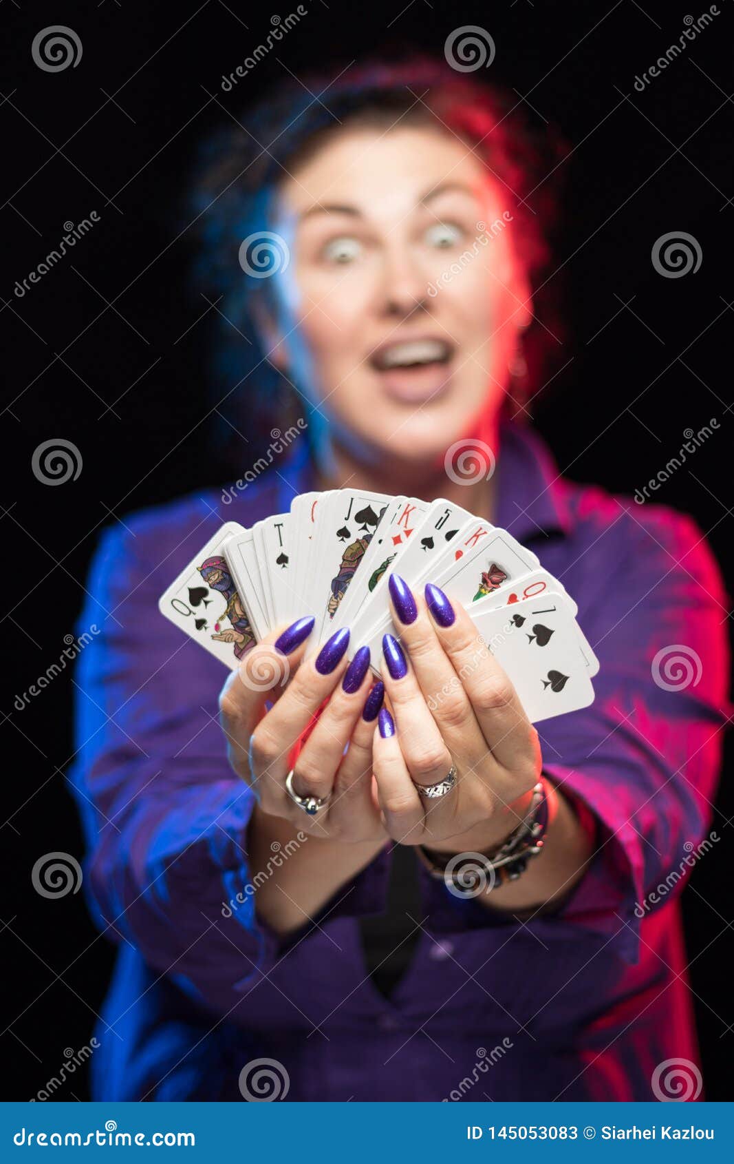 A Woman in Purple Clothes Holds a Deck of Cards and Shows Tricks Stock ...