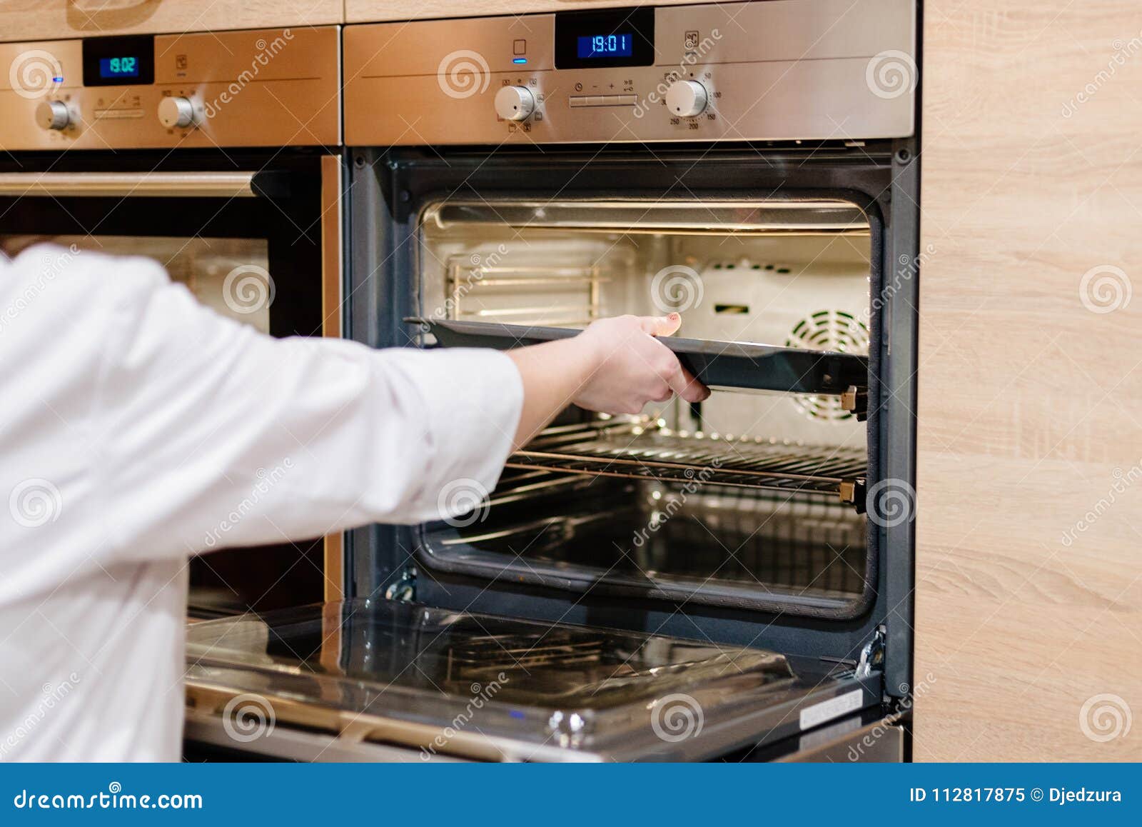 Woman puts the baking tray stock image. Image of housekeeping 112817875