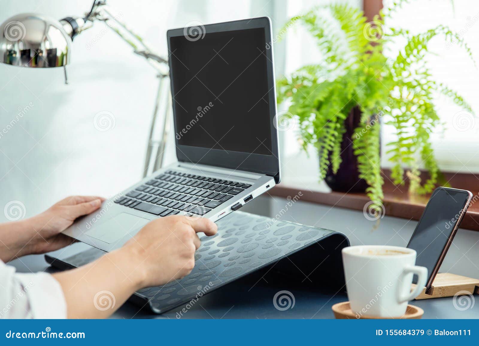 woman puts ultrabook to laptop`s stand