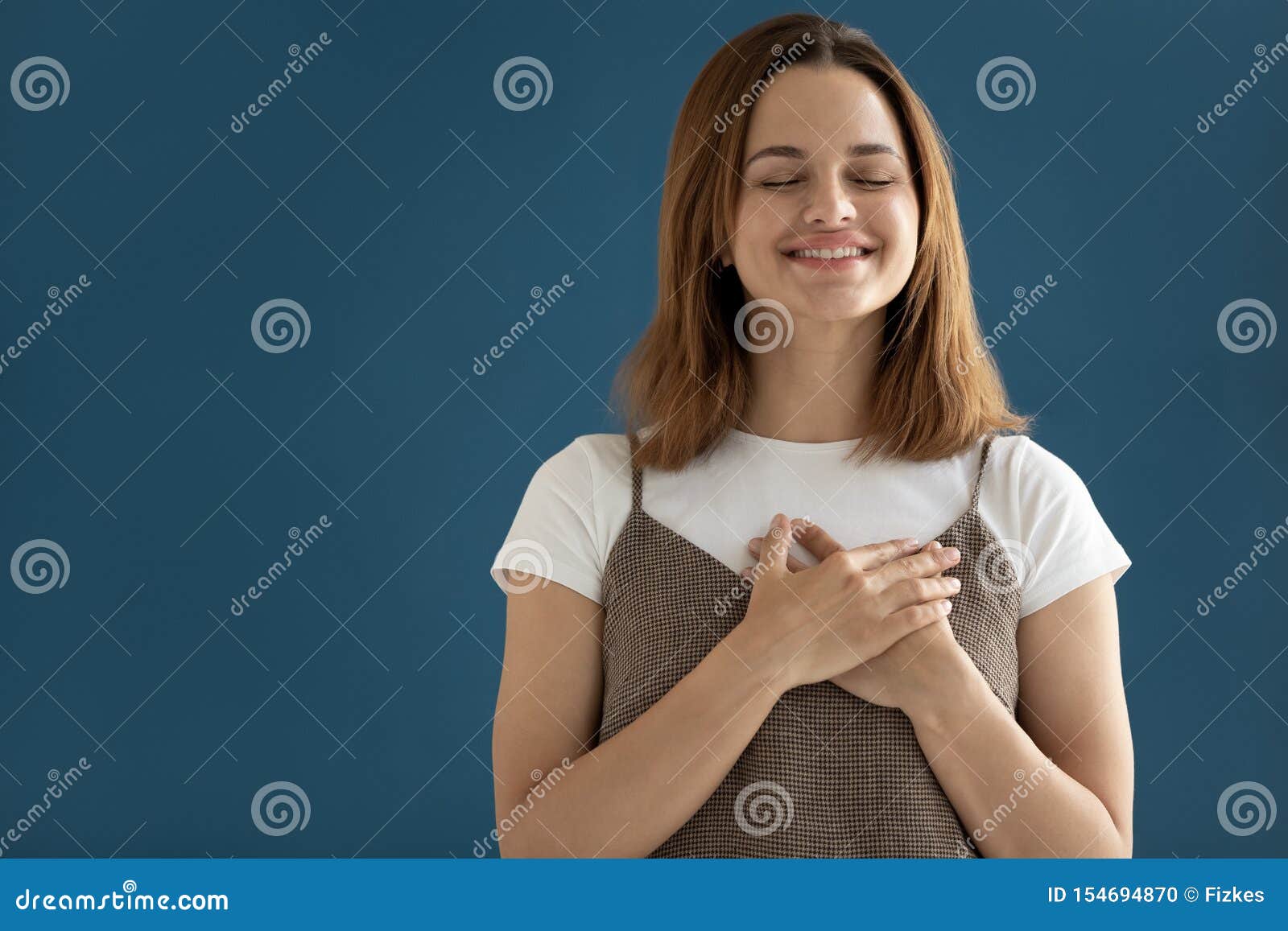 woman putting hands on chest showing appreciation studio shot