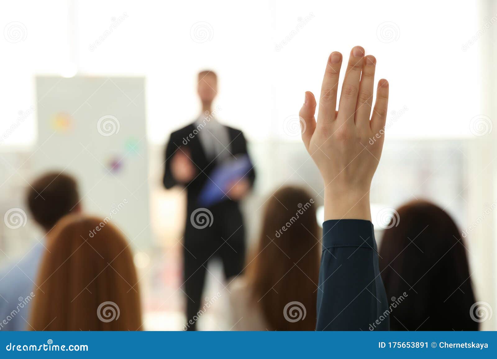 woman raising hand to ask question at business training indoors, closeup