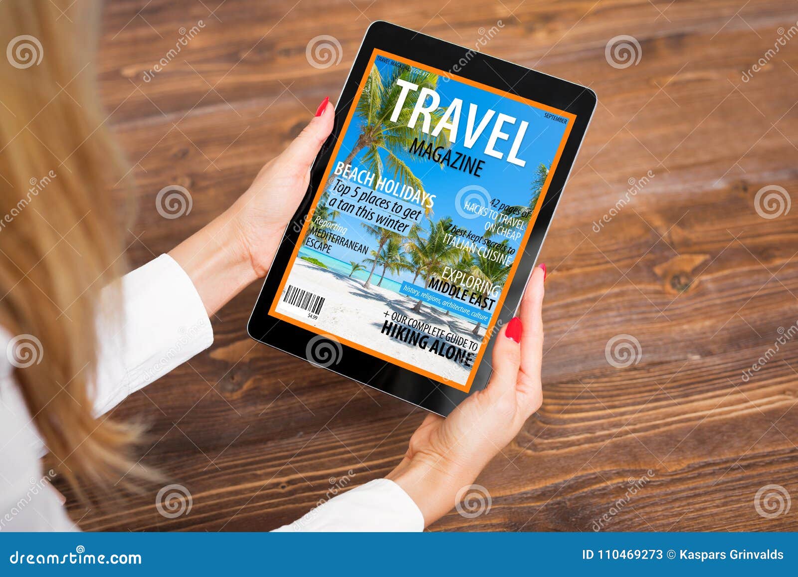 woman reading travel magazine on tablet