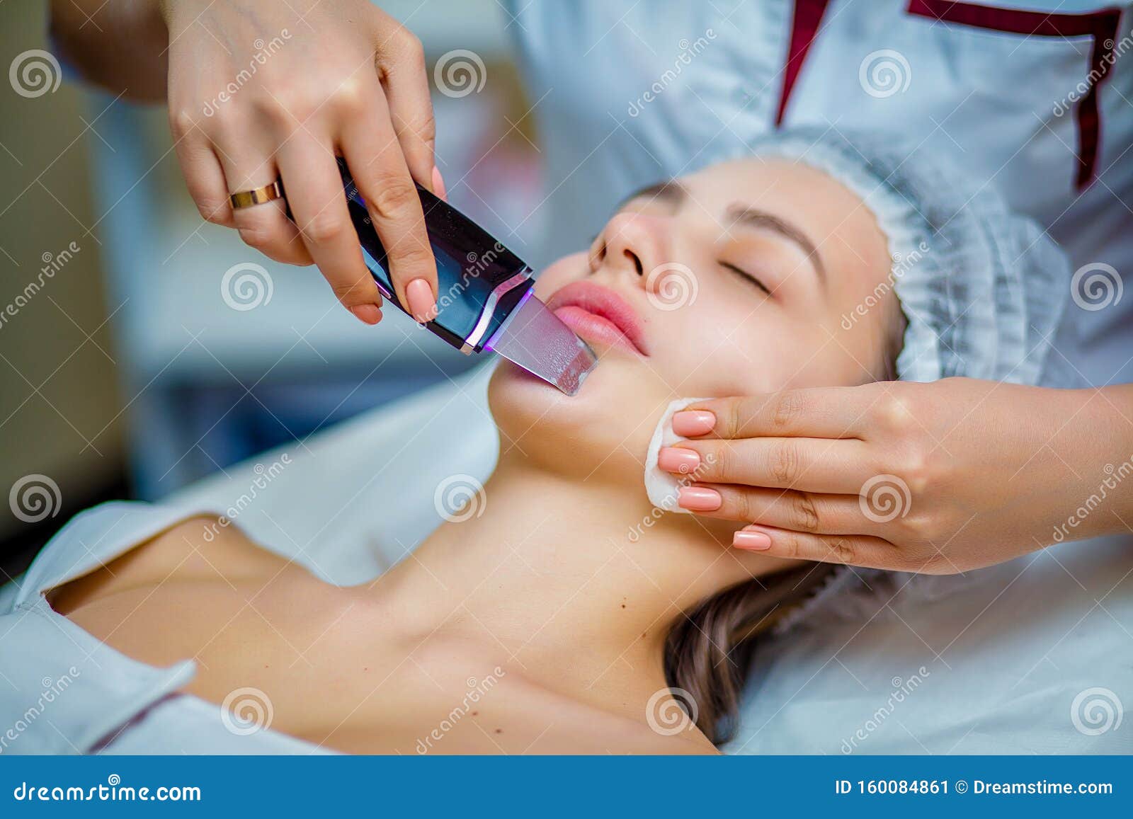 woman receiving ultrasonic facial exfoliation at cosmetology salon.
